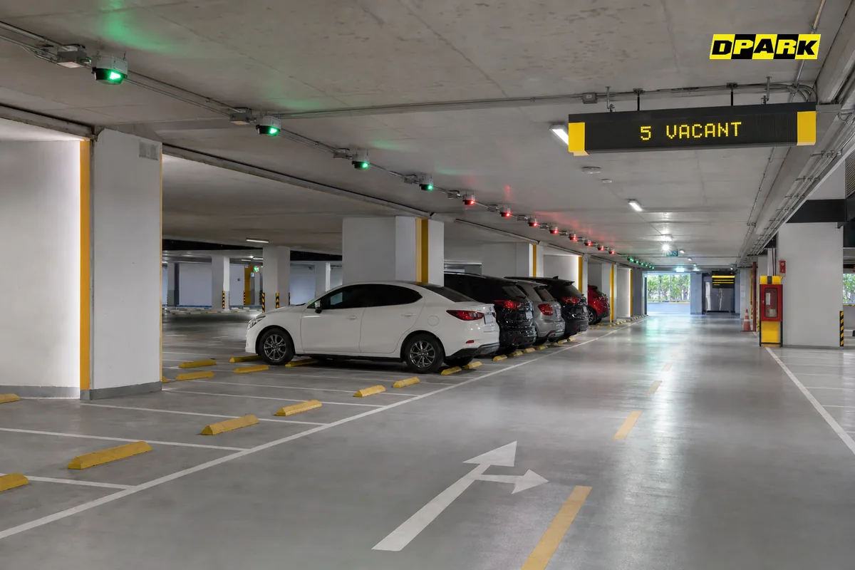 ระบบนำทางลานจอดรถ DPARK — ไฟ LED เขียว-แดงเหนือช่องจอดในอาคารจอดรถ แสดงสถานะว่างและไม่ว่างแบบ real-time